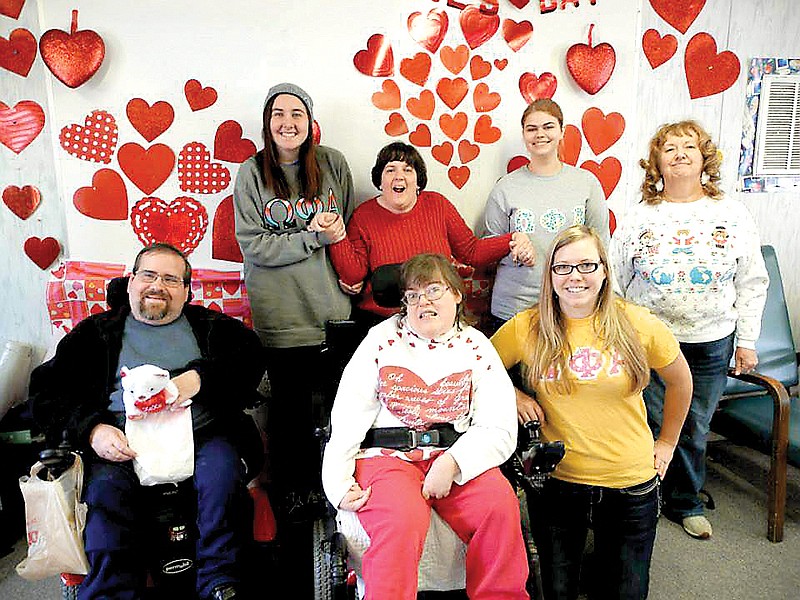 Members of Omega Phi Alpha sorority pose with participants in Signal Centers' Adult Program at the Valentine's Day party thrown by the sorority for the nonprofit.