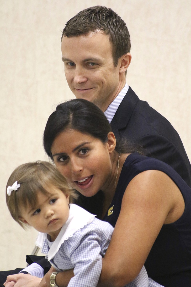 Matt McCall and his wife Allison watch as their daughter Brooklyn becomes intrigued by Scrappy during a press conference announcing McCall as the University of Tennessee at Chattanooga's new head men's basketball coach while at the UTC University Center on Monday, April 14, 2015. 