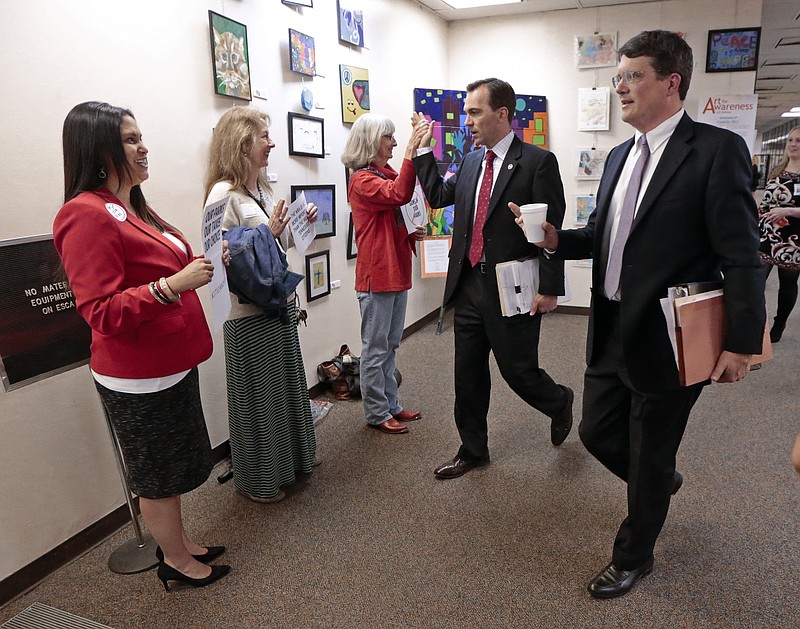 Rep. Mike Stewart, D-Nashville, right, and Rep. John Ray Clemmons, D-Nashville, second from right, pass people protesting a bill allowing guns in parks before a House season Monday, April 6, 2015, in Nashville.