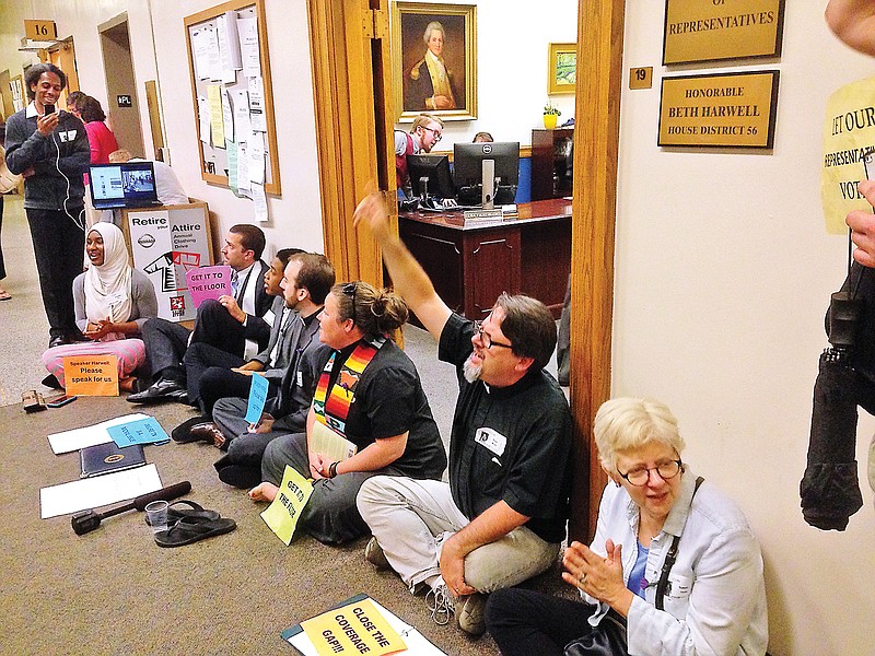 The Rev. Brian Merritt of Chattanooga, second from right, leads demonstrators in a sitdown protest in favor of Insure Tennessee in front of Beth Harwell's office on Tuesday.