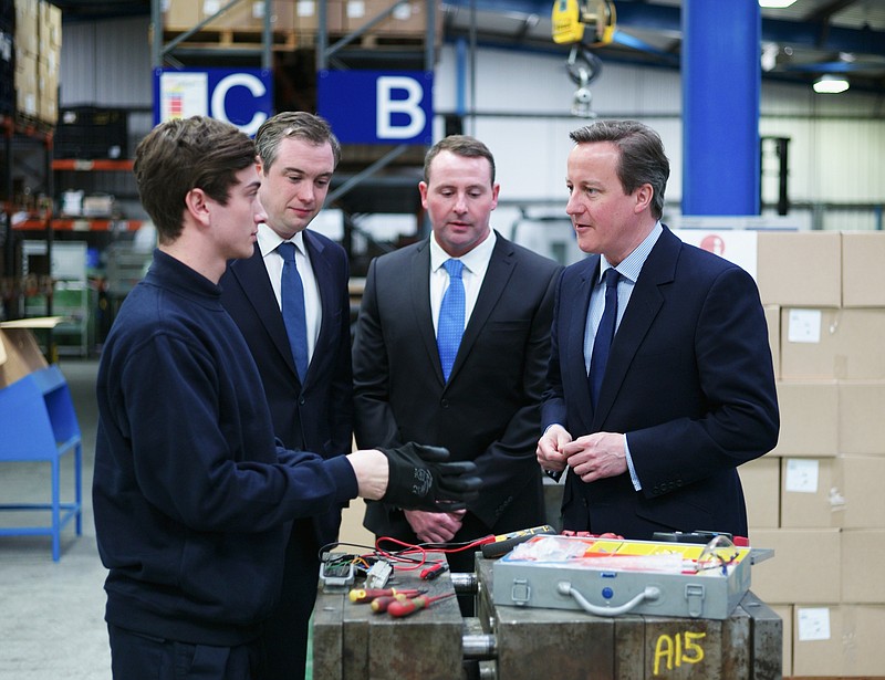 
              Britain's Prime Minister David Cameron, right, talks to apprentice Tom Walsh, 20, left, during a visit to a plastics manufacturing factory in Stockton, England, Monday April 13, 2015. Britain goes to the polls in a General Election on May 7. (Ian Forsyth/Pool Photo via AP)
            