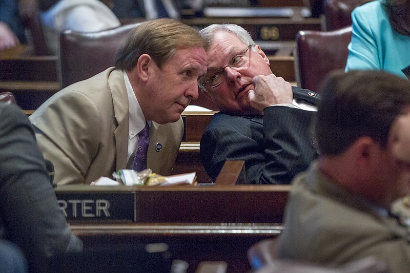 Republican Reps. Mike Carter, of Chattanooga, left, and Curtis Johnson, of Clarksville, confer during a House floor debate, Tuesday, April 14, 2015, in Nashville.