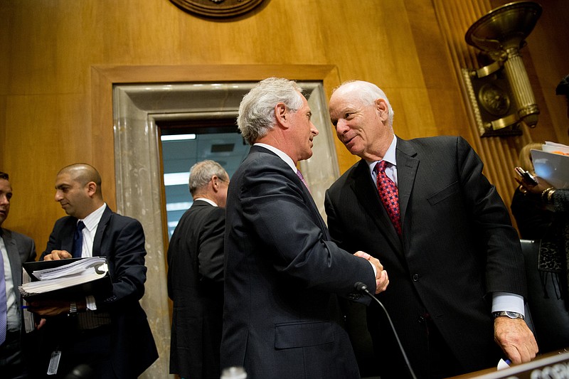 Senate Foreign Relations Committee Chairman Sen. Bob Corker, R-Tenn., center, shakes hands with the committee's ranking member Sen. Ben Cardin, D-Md., on Capitol Hill in Washington, Tuesday, April 14, 2015, after the committee passed the Iran Nuclear Agreement Review Act of 2015.