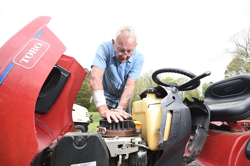 Jack Wilson diagnoses an engine problem on a riding lawnmower at the small engine repair shop at his home south of Cleveland on April 13, 2015. Jack's Small Engine has been his business since he left the Army in 1979.