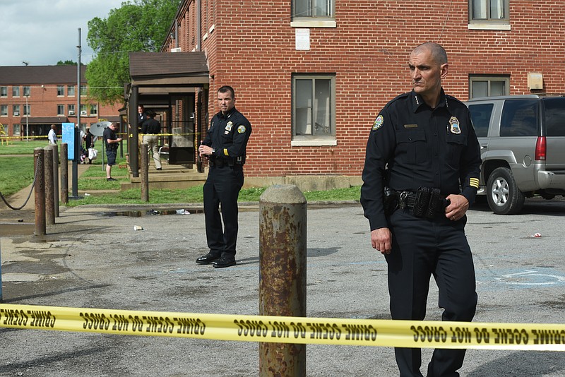 Chattanooga Police Chief Fred Fletcher, right, and Chief of Staff David Roddy, back center, survey the surroundings Wednesday, April 15, 2015, following a homicide in College Hill Courts.