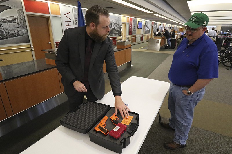 Mark Howell, public affairs spokesman for the Transportation Security Administration, informs Dalton, Ga., resident Brian Davis how to properly fly with a firearm while at the Chattanooga Airport on April 16, 2015.