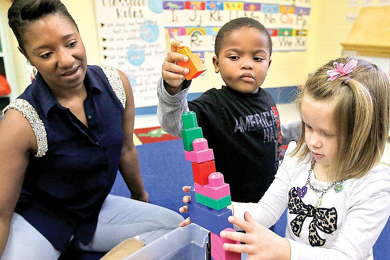 Instructor Monica Rucker, left, watches as Bryson Harris, center, and Sophia Brannen play with blocks at the Chambliss Center for Children in this Dec. 23, 2014, file photo.