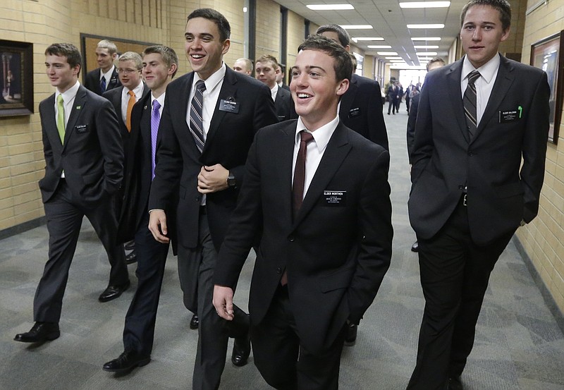 
              FILE - In this Jan. 8, 2013, file photo, Mormon missionaries walk through the halls at the Missionary Training Center in Provo, Utah. A record number of young Mormons signed up for missions after church leaders lowered the minimum age in 2012, but new figures show the onslaught of proselytizing Latter-day Saints didn't lead to an equally dramatic spike in converts. (AP Photo/Rick Bowmer, File)
            