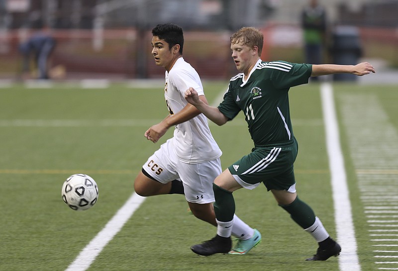 Chattanooga Christian School's Drew Bolano (11) and Notre Dame's Rhys Robertson (11) chase down the ball during their game at the Charger's home field on Friday, April 17, 2015.