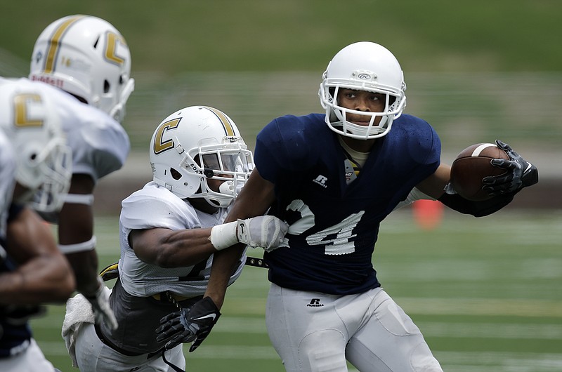 UTC defensive back Oxcar Prado, left, tackles wide receiver DeJuan McQuarters during the Mocs' spring Blue and White football game Saturday, April 18, 2015, at Finley Stadium in Chattanooga. The white team won 6-0.