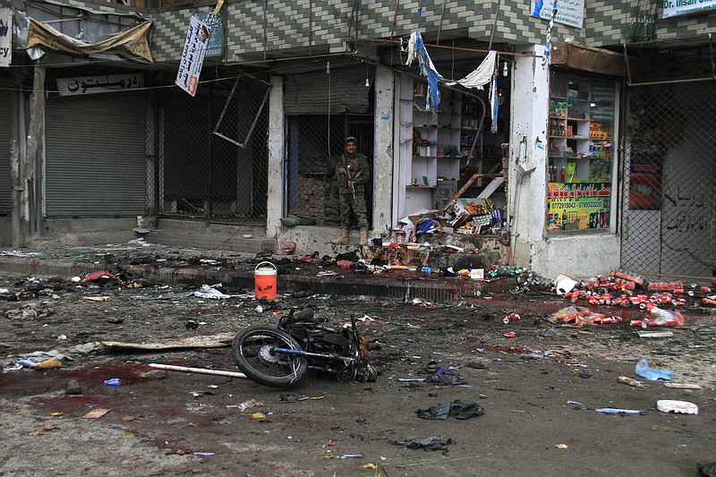 An Afghan security forces inspect at the site of suicide attack near to new Kabul Bank in Jalalabad east of Kabul, Afghanistan, Saturday, April, 18, 2015. 