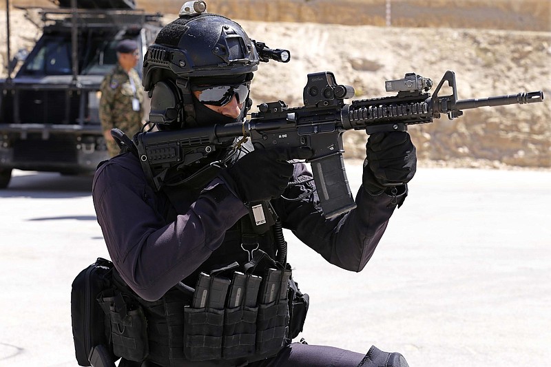 
              Jordanian forces conduct a military drill as part of the 7th Annual International Warrior Competition hosted by the King Abduallh Special Operations Training Center (KASOTC), Sunday, April 19, 2015, Amman, Jordan.  Jordan is hosting a competition of elite anti-terrorism squads from 18 countries, including fellow members of the military coalitions fighting rebels in Yemen and Islamic State extremists in Iraq and Syria. The competition opened Sunday with a drill by Jordanian special forces rescuing hostages from a plane and rappelling from a helicopter. (AP Photo/Raad Adayleh)
            