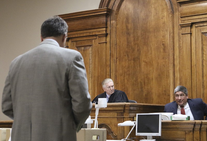 District Attorney Herbert "Buzz" Franklin speaks to Assistant District Attorney Chris Arnt while he is on the stand appearing before Cobb County Superior Court Senior Judge Grant Brantley during a pre-trial hearing to determine if FBI agent Ken Hillman is guilty of impropriety while at the Catoosa County Courthouse on Monday, April 19, 2015. 