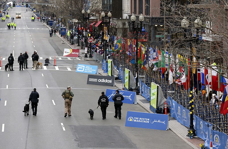
              Police flank an explosive ordnance disposal officer, second from left, as they patrol past the site of the first 2013 bombing site before the start of the Boston Marathon Monday, April 20, 2015 in Boston. (AP Photo/Charles Krupa)
            