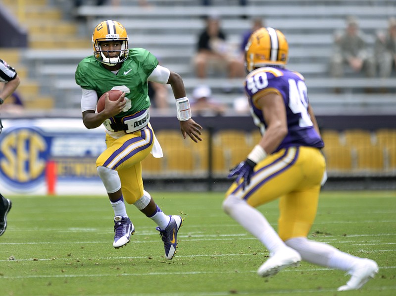 LSU quarterback Brandon Harris, left, tucks the ball away and sprints out of the pocket, pursued by linebacker Duke riley (40) during the NCAA college football team's spring football game Saturday, April 18, 2015, in Baton Rouge, La.