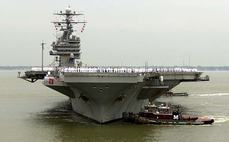 FILE - In tbhis May 29, 2003 file photo, sailors man the rails as the USS Theodore Roosevelt is manuvered into it's berth at the Norfolk Naval Station in Norfolk, Va. U.S. Navy officials say the aircraft carrier USS Theodore Roosevelt is steaming toward the waters off Yemen and will join other American ships prepared to intercept any Iranian vessels carrying weapons to the rebels fighting in Yemen. (AP Photo/Steve Helber, File)