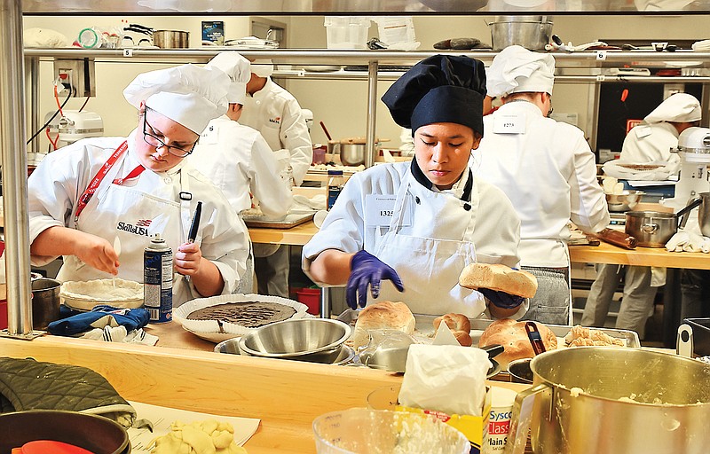 High school students Mackensie Davis, left, and Bay Dedicatoria compete in the SkillsUSA State Culinary Competition making pastry
items on the clock Tuesday at the Culinary Institute of Virginia College. Davis is from Stone Memorial High School in Crossville, Tenn.
Dedicatoria is from Cleveland High School.
