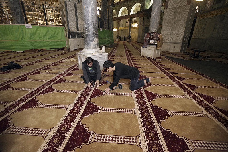 
              In this Sunday, April 19, 2015 photo, workers place new carpets at the Dome of the Rock shrine in Jerusalem. The Dome of the Rock enshrines the large rock slab where Muslim tradition says Mohammed ascended to heaven. Jews believe the rock may be where the holiest part of the two ancient temples stood about 2,000 years ago. (AP Photo/Mahmoud Illean)
            