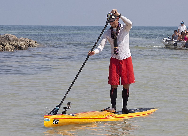 In this photo provided by the Florida Keys News Bureau, Ben Friberg paddles the last few yards to arrive in Key West, Fla., Friday, Aug. 2, 2013, after completing an 111-mile voyage from Cuba across the Florida Straits to the Florida Keys. Friberg, a Chattanooga musician, finished the trip from Marina Hemingway near Havana to Key West's Smathers Beach in 28 hours and 6 minutes.