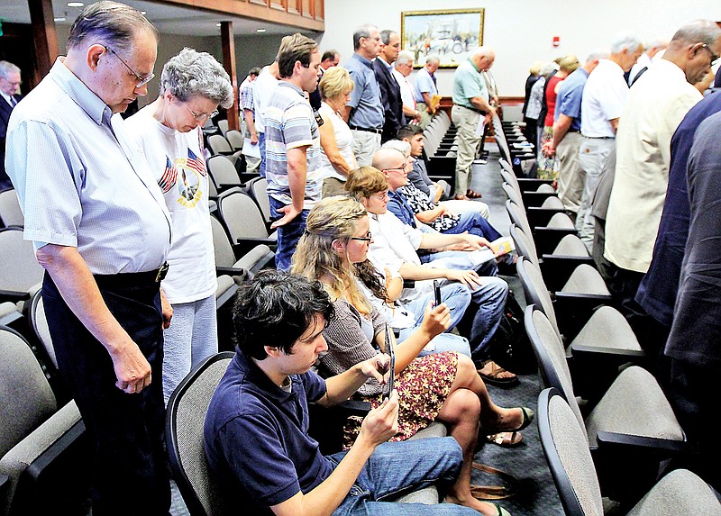 Protesters remain seated during an opening prayer at a Hamilton County Commission meeting. Judge Harry S. Mattice ruled Wednesday, April 22, 2015, that the practice of allowing prayer before commission meetings is constitutional.