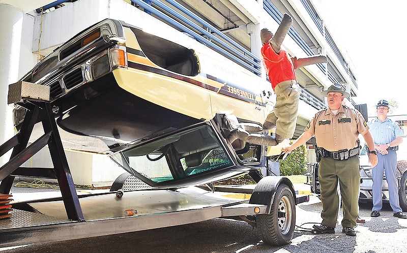 A dummy flies from a car during a rollover demonstration as Sgt. Alan Bailey, left, and Trooper Steve Langham watch Wednesday, April 22, 2015, at Erlanger.