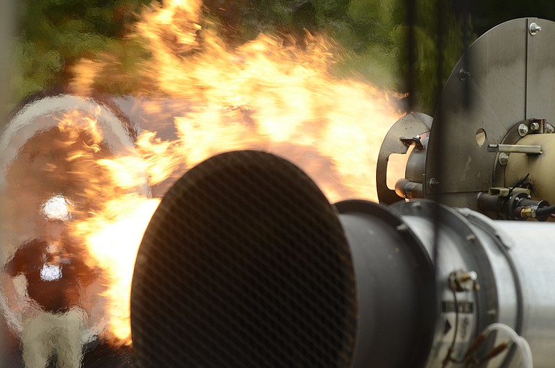 Workers do a burn test on a piece of equipment at the Astec manufacturing facility in Chattanooga.