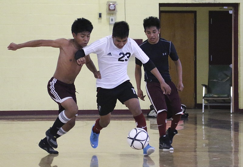 Kevin Pascual, Bersain Tomas-Mendez and Juan Andres-Felipe, from left, battle for possession of the ball during soccer practice in the gymnasium at Howard School on Friday, April 17, 2015. This is the first year Howard has had a soccer team after dismantling the program years ago. 