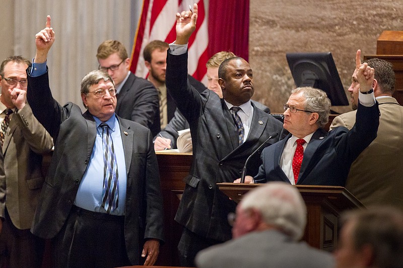 
              Supporters of a bill to extend in-state tuition to non-citizens who are lawfully present in the United States signal their position on a motion from the well of the House chamber on Wednesday, April 22, 2015 in Nashville, Tenn.. From right are Reps. Mark White, R-Memphis; Joe Towns, D-Memphis, and Harry Brooks, R-Knoxville.  (AP Photo/Erik Schelzig.)
            