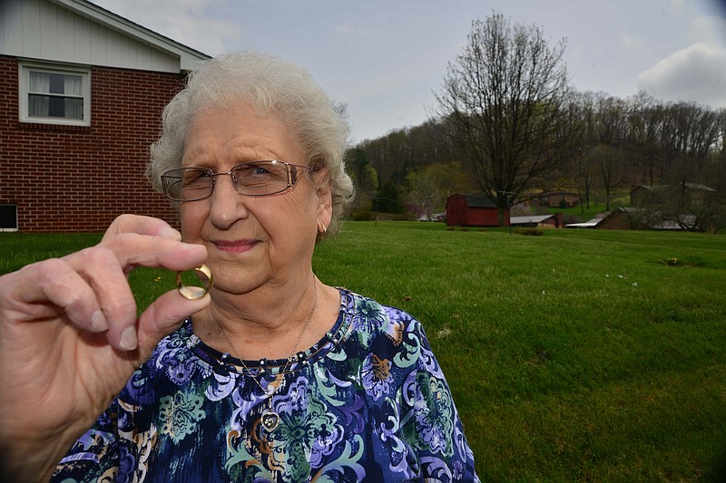 In this April 8, 2015, photo, Ruth Jones poses for a photo as she holds a wedding ring she lost over 55 years ago in Kingsport, Tenn. The ring was found by her 9-year-old great-grandson Noah Gilliam.