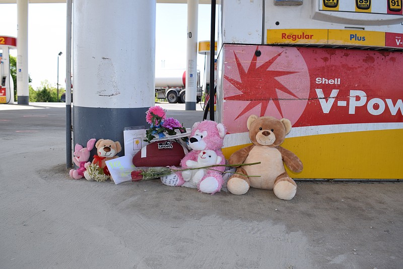 A small memorial stands Friday, April 24, 2015, at the Shell station gas pumps on Cleveland Highway in Varnell, Ga., where 37-year-old Christopher Eric Whitmore gunned down his 8-year-old son Grayden Lee and 27-year-old Melissa Ball before turning the weapon on himself Thursday night.