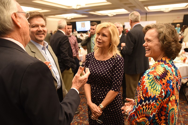 Debbie McKee-Fowler, right, her husband Randy Fowler, second from left, and his sister DeAnn Fowler, talk with Ben Wygal, left, at the 2015 Tennessee Women of Distinction event Friday at the Chattanooga Convention Center.