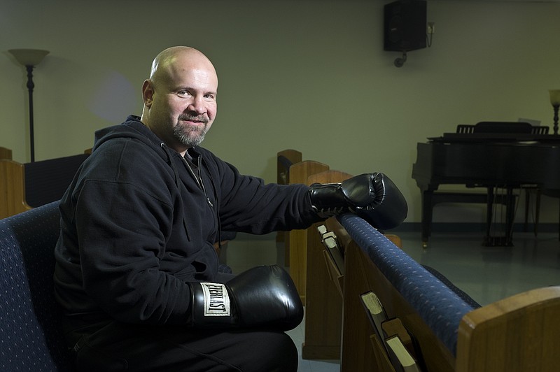 Even as a professional boxer, Adam Sutton says he felt God's hand at work and the need to reach out to others. He hasn't boxed professionally in more than a decade and was recently ordained at Cleveland Community Chapel. Inset above is a shadowbox of Sutton's boxing memorabilia.