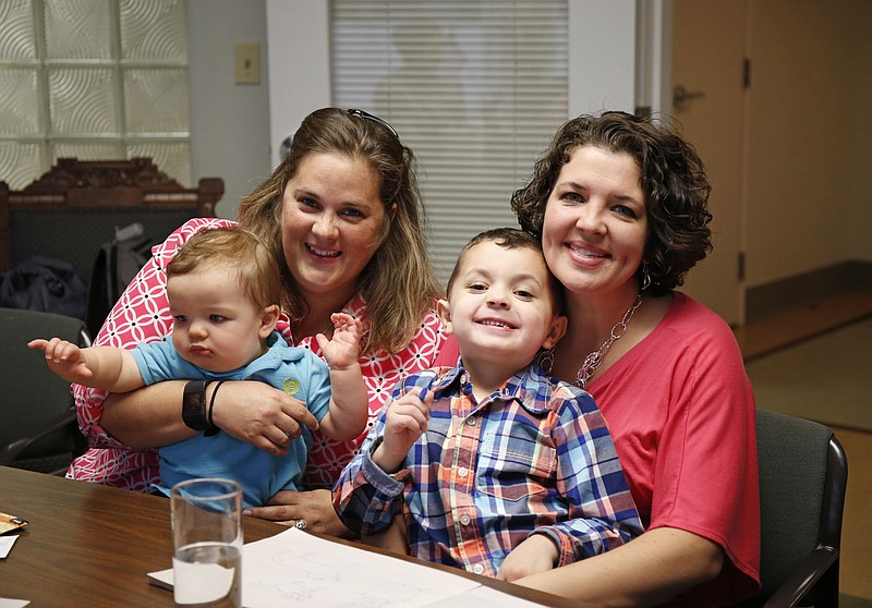 
              Pam Yorksmith, left, and her spouse Nicole Yorksmith, along with their children, Grayden, 4, and Orion, are photographed in the office of their attorney, Gerhardstein & Branch Co. LPA, Friday, April 3, 2015 in Cincinnati. A middle-of-the night trip to the emergency room, with her 9-month-old son coughing and laboring to breathe, gave Pam Yorksmith her latest reminder of why she took up the fight for same-sex marriage. Before baby Orion could be treated for croup, the hospital had to call his birth mother, Yorksmith’s wife, Nicole, "to get permission to treat my child," Yorksmith said. The are among the 19 men and 12 women whose same-sex marriage cases from those two states, plus Michigan and Tennessee, will be argued at the Supreme Court on April 28. (AP Photo/Gary Landers)
            