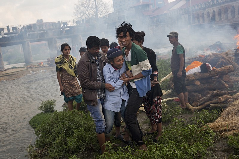 
              A Hindu man breaks down during a funeral of Saturday’s earthquake victims on the Pashupatinath bank of Bagmati river, in Kathmandu, Nepal, Sunday, April 26, 2015.  The earthquake centered outside Kathmandu, the capital, was the worst to hit the South Asian nation in over 80 years. It destroyed swaths of the oldest neighborhoods of Kathmandu, and was strong enough to be felt all across parts of India, Bangladesh, China's region of Tibet and Pakistan.(AP Photo/Bernat Armangue)
            