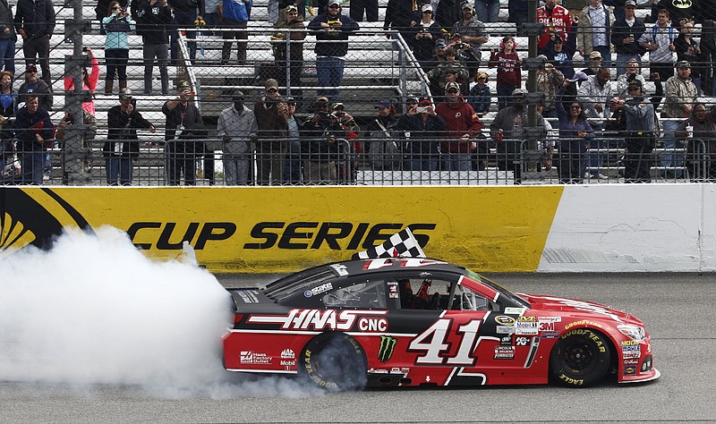 Kurt Busch does a burnout as he celebrates after winning the NASCAR Sprint Cup auto race at Richmond International Raceway in Richmond, Va., Sunday, April 26, 2015.