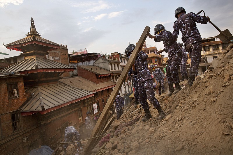 Nepalese policemen clear the debris at Basantapur Durbar Square, damaged in Saturday's earthquake, in Kathmandu, Nepal, Sunday, April 26, 2015. 