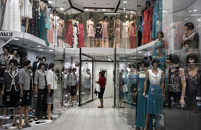 
              A woman checks garments at a shop in central Athens, on Monday, April 27, 2015.  An opinion poll shows a majority of Greeks are dissatisfied with the new government's performance, and half want it to compromise with its European creditors if current tortuous bailout negotiations reach an impasse.  (AP Photo/Yorgos Karahalis)
            