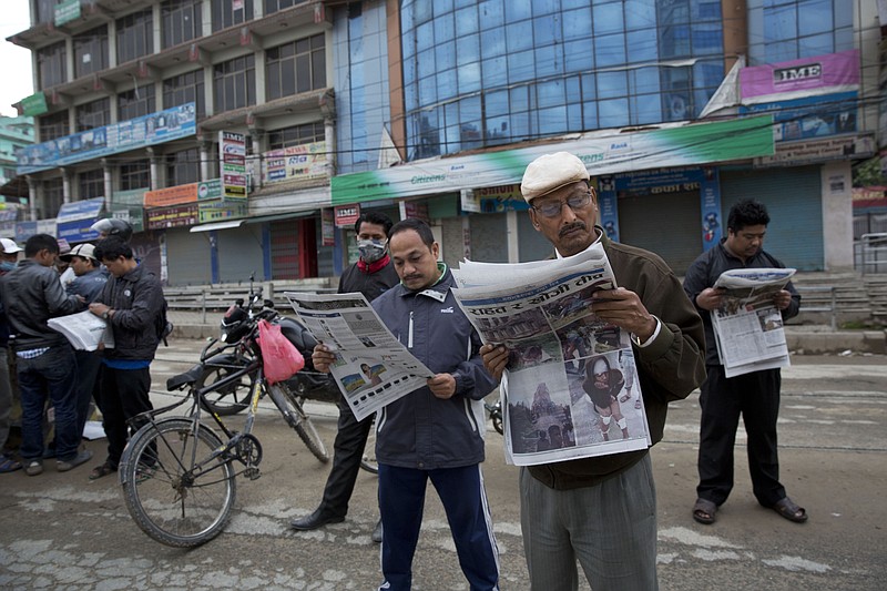 
              Locals read morning edition of a newspaper as they stand in the middle of a street in Kathmandu, Nepal, Monday, April 27, 2015. A strong magnitude earthquake shook Nepal’s capital and the densely populated Kathmandu valley on Saturday devastating the region and leaving tens of thousands shell-shocked and sleeping in streets. (AP Photo/Bernat Armangue)
            