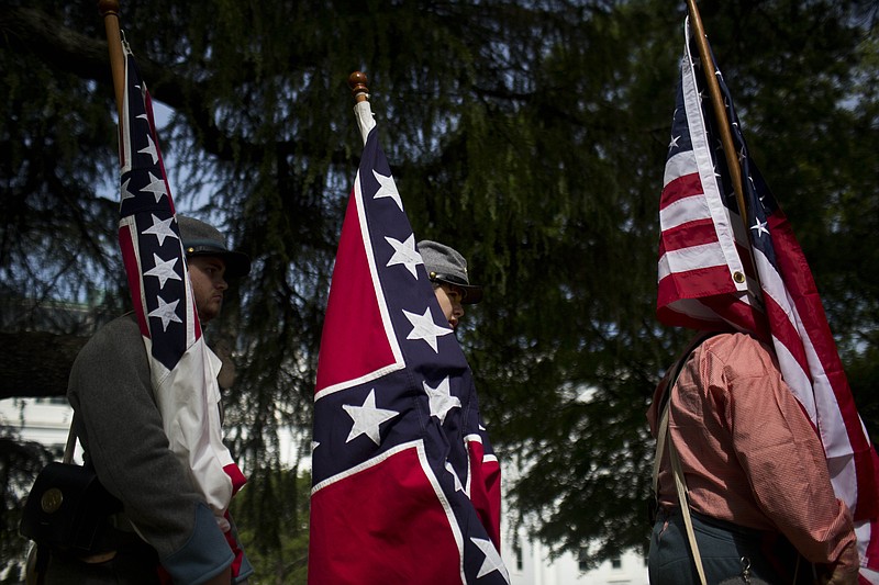 Brandon Grant, of Troy, Ala., left, and Jakan Kyle, of Elba, center, carry confederate flags near the Alabama State Capitol during Confederate Memorial Day on Monday, April 27, 2015, in Montgomery, Ala.