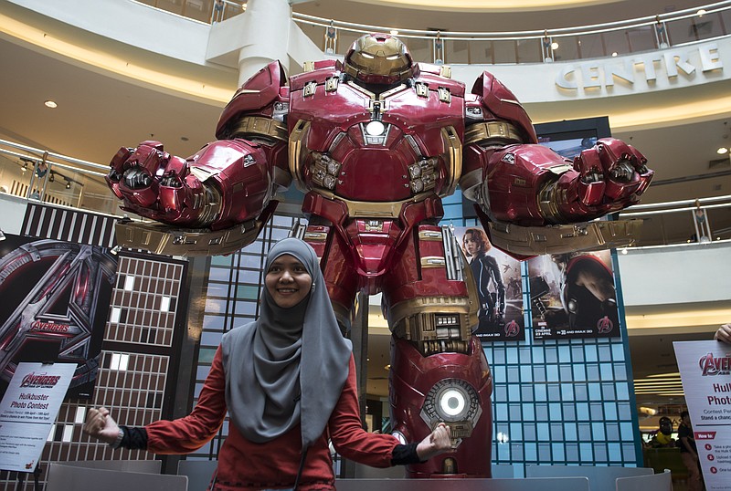 
              FILE - In this April 10, 2015 file photo, a Malaysian Muslim woman poses with a Hulkbuster statue from "Avengers: Age of Ultron" at a mall in Kuala Lumpur, Malaysia. Several hundred movie theaters in Germany have refused to screen the new "Avengers" film in a dispute over rental fees with Disney. News agency dpa reported that 686 theaters in 193 mostly small towns refused to show "Avengers: Age of Ultron," which opened on Thursday, April 23. (AP Photo/Joshua Paul, File)
            