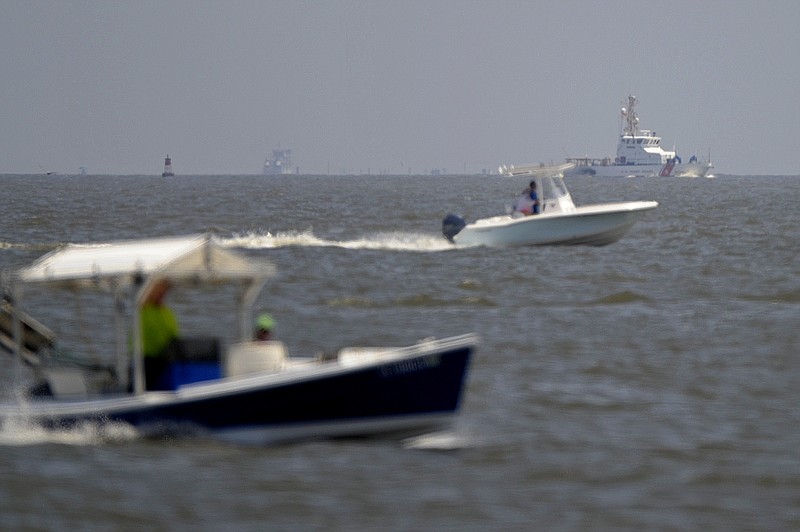 
              A U.S. Coast Guard boat, top right, patrols Mobile Bay as other water craft head head south from Dauphin Island, Ala., Sunday, April 26, 2015. Coast Guard crews are searching for five people missing in the water after a powerful storm capsized several sailboats participating in a regatta near Mobile Bay. (AP Photo/G.M. Andrews)
            