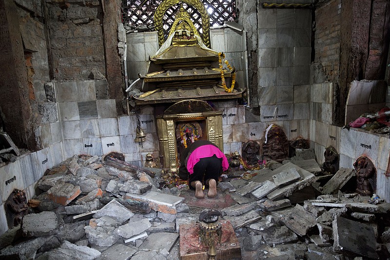 
              A Hindu Nepalese woman offers prayers at Indrayani temple, that was damaged in Saturday’s earthquake, in Kathmandu, Nepal, Monday, April 27, 2015. A strong magnitude earthquake shook Nepal’s capital and the densely populated Kathmandu valley on Saturday devastating the region and leaving tens of thousands shell-shocked and sleeping in streets. (AP Photo/Bernat Armangue)
            