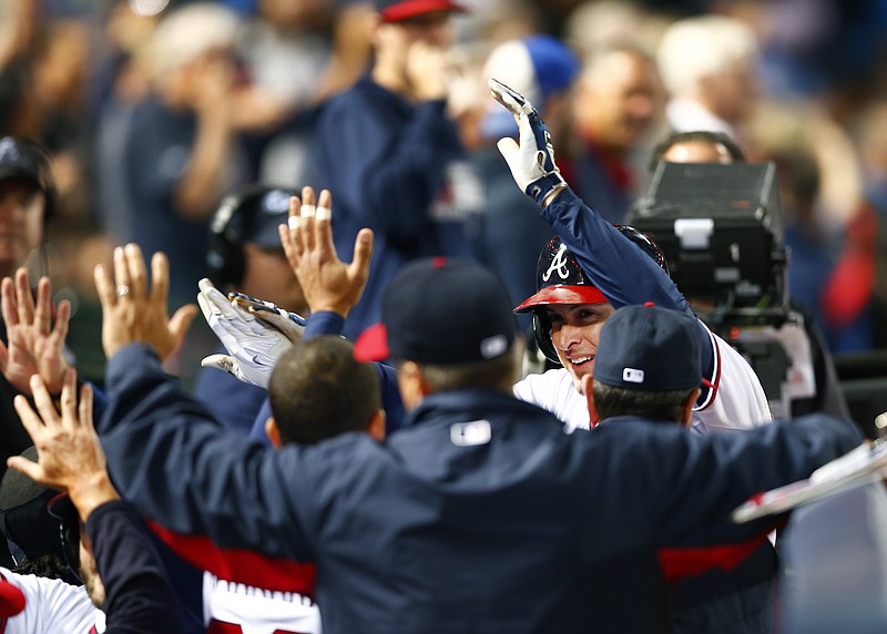 Atlanta Braves left fielder Kelly Johnson, right, is greeted at the dugout by his teammates after hitting a two-run home run in the sixth inning of a baseball game against the Washington Nationals on Monday, April 27, 2015, in Atlanta. 