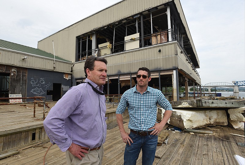 Harry Phillips, left, and Brock Sparks talk Tuesday about the process of raising the Allen Casey barge from the Tennessee River's bed so it can be moved.