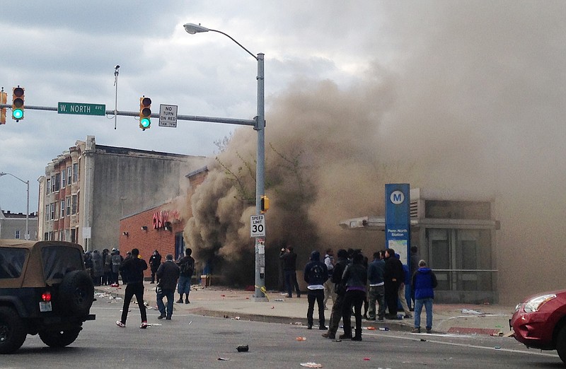 
              Smoke billows from a CVS Pharmacy store in  Baltimore on Monday, April 27, 2015. Demonstrators clashed with police after the funeral of Freddie Gray. Gray died from spinal injuries about a week after he was arrested and transported in a Baltimore Police Department van. (AP Photo/Juliet Linderman)
            