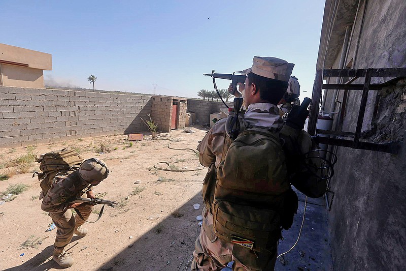 
              In this Sunday, April 26, 2015 photo, Iraqi security forces clash with Islamic State group militants, during an operation to retake the water control station on a canal lost over the weekend, in the town of Garma, between Baghdad and the Islamic State-held city of Fallujah, Iraq. Defense Minister Khalid al-Obeidi said on Iraqi television that the army has achieved "90 percent" of its objectives in the town of Garma. (AP Photo)
            