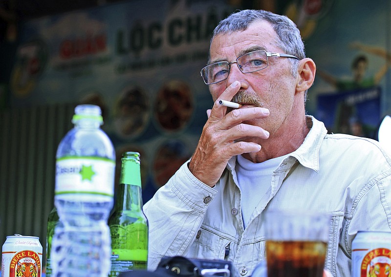 In this April 11, 2015, photo, Richard Parker, a Vietnam war veteran, smokes a cigarette as he drinks beer with other fellow veterans in Danang, Vietnam. The presence of American war veterans in today's Vietnam - and the warm welcome they usually receive - is yet another sign of how much the U.S.-Vietnamese relationship has evolved since the countries normalized relations in 1995. (AP Photo/Hau Dinh)