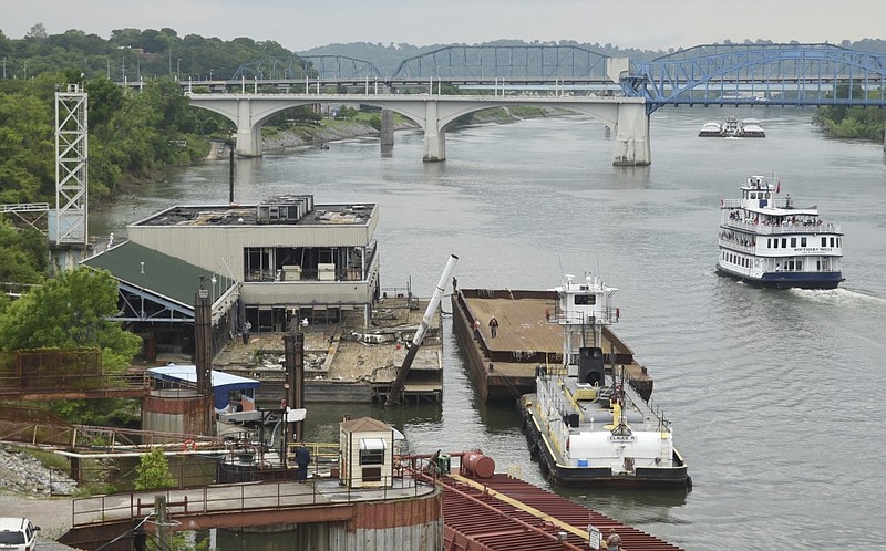 The towboat Claude R moves in Wednesday, April 29, 2015, as workers prepare to remove the Casey barge from its downtown riverfront berth. At right in the foreground is the excursion boat the Southern Belle.