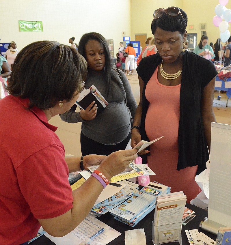 Expectant mothers Ashley Harris and Rishunda Bryant, right, talk with Melody Chambers, left, of the Signal Centers as they attend a health fair at the Brainerd Complex in Chattanooga.