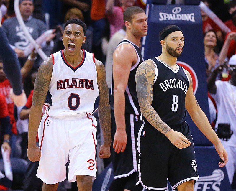 Atlanta Hawks guard Jeff Teague (0) reacts to scoring against Brooklyn Nets Brook Lopez and Deron Williams (8) in the final minutes of a 107-97 victory over the Nets in their first round, game on Wednesday, April 29, 2015, in Atlanta. Curtis Compton(/Atlanta Journal-Constitution via AP) 